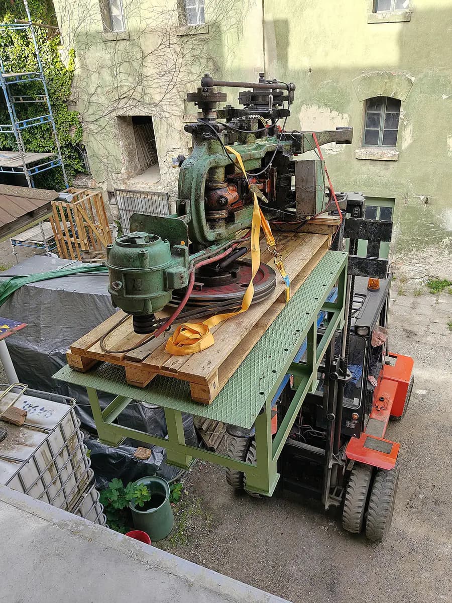 Stroj na plošině vysokozdvižného vozíku na dvoře pivovaru.